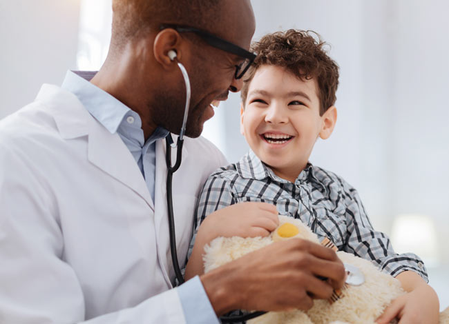 African American male doctor holding a young patient