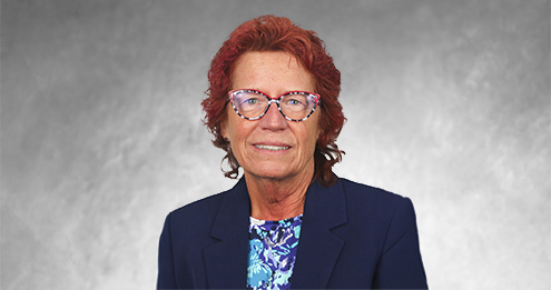 Middle-aged caucasian woman with short read hair wearing glasses