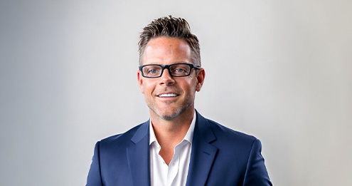 Middle-aged Caucasian man with short black hair wearing glasses