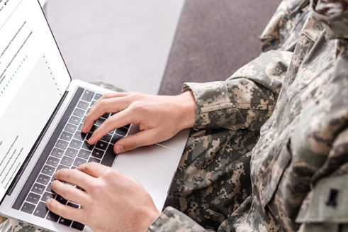 Soldier typing on laptop