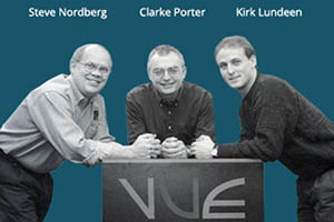 The three founders of VUE leaning on a table that says VUE